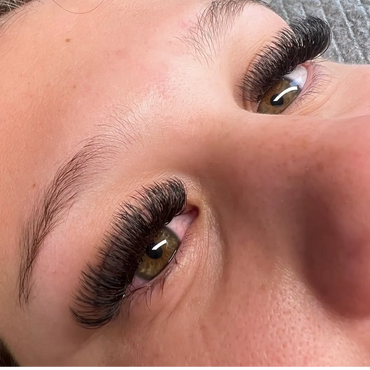 Close-up of eyes with thick, voluminous eyelash extensions.