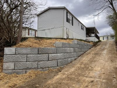 Mobile home with retaining wall and driveway.