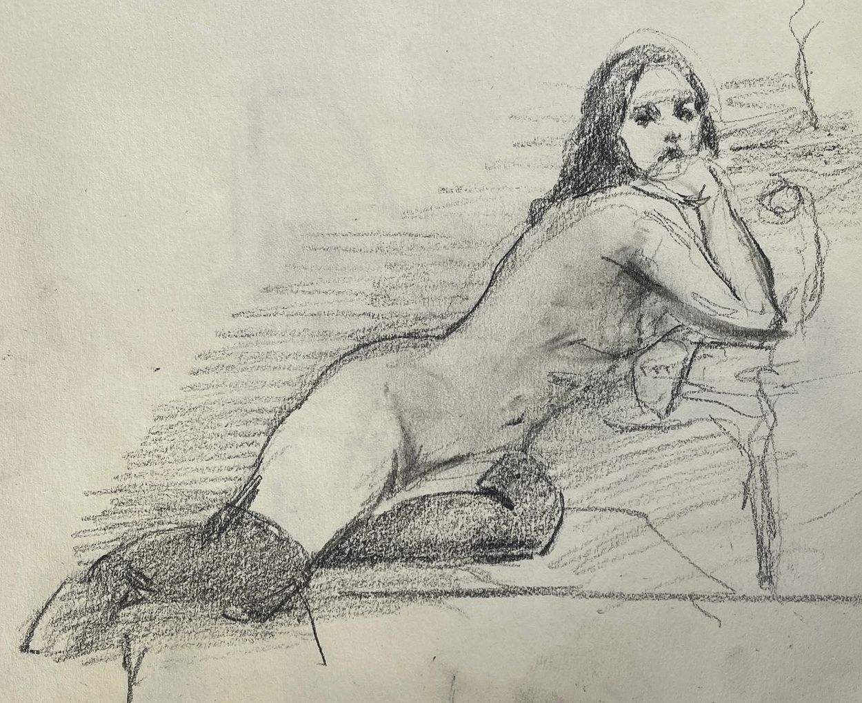Charcoal sketch of a woman reclining with thoughtful expression.