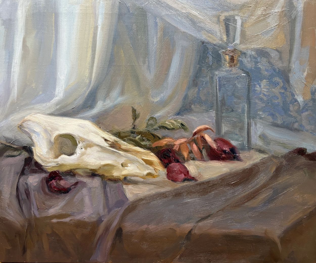 Still life painting of animal skull, dried leaves, and glass bottle on draped fabric.