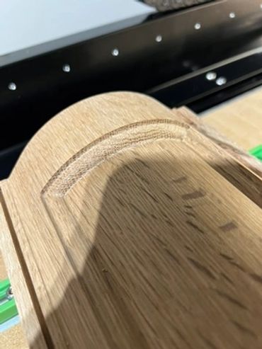 Close-up of the routed profile and wood grain on a curved wood component.