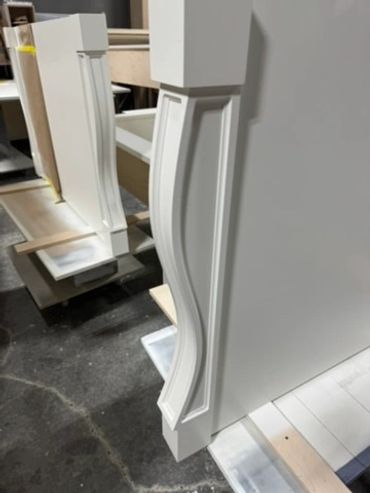Painted white architectural details with curved edges and recessed profiles in the workshop.