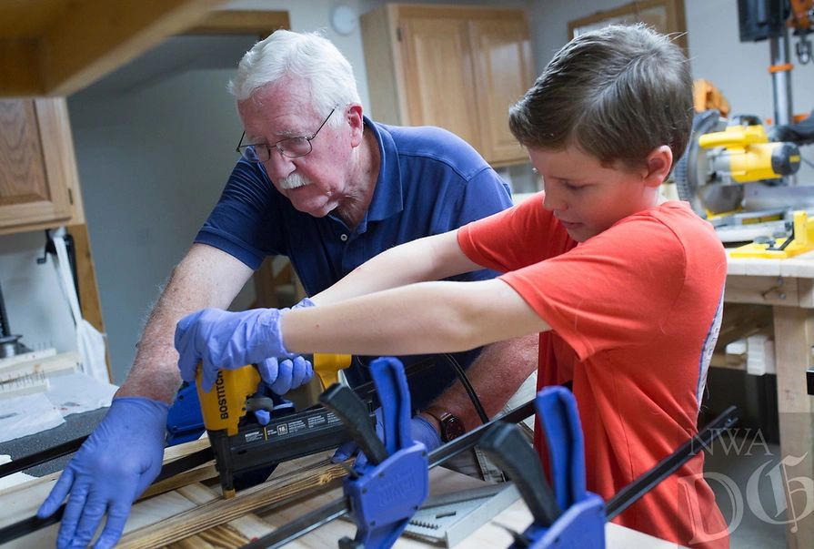 Jeremiah nailing on the back braces. He loves making rustic wooden flags.