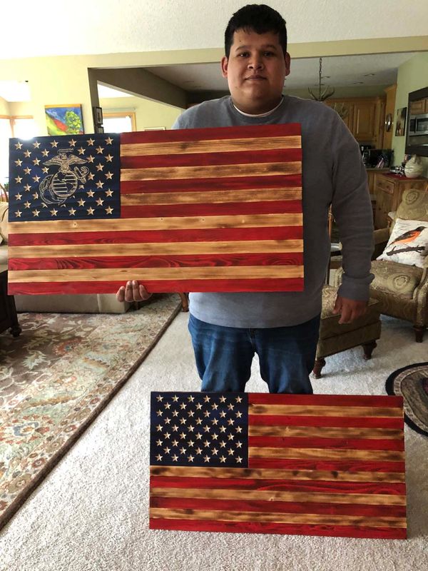 A proud Marine Corps Veteran with his USMC flag and a  traditional 50 star flag.