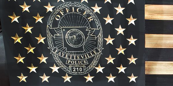 Close-up of the detailed badge carving of a Fayetteville, Arkansas Police badge.
