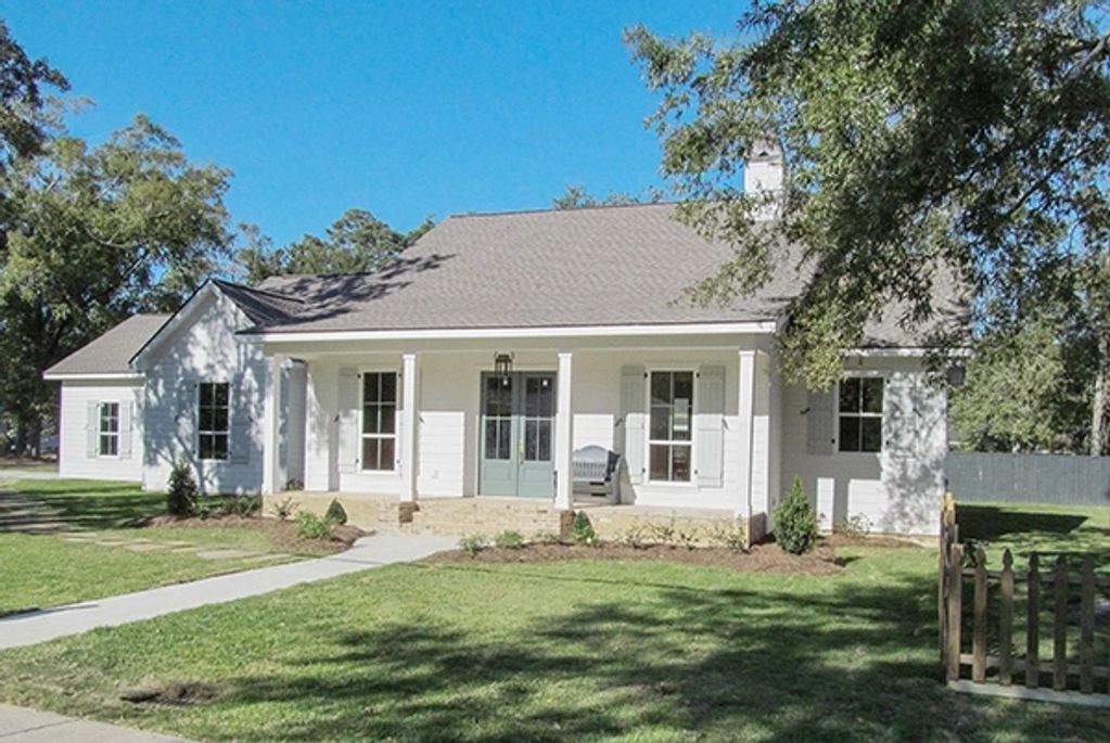 Single-story custom white home with light gray shutters, front porch, and stone walkway.