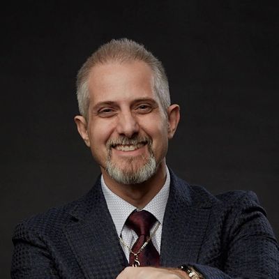 Smiling confident man in a suit with a goatee.
