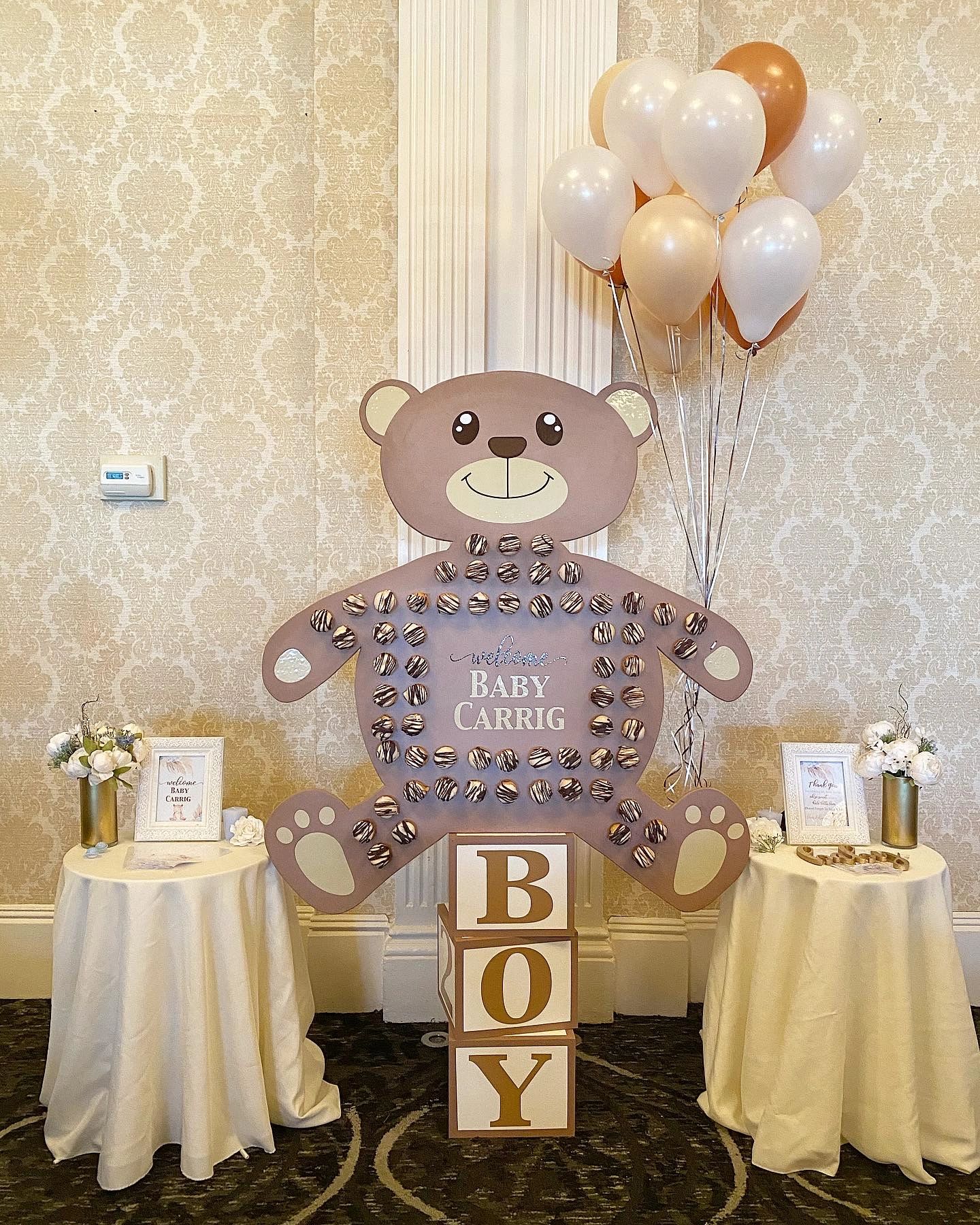 Baby shower decoration with teddy bear, balloons, and baby blocks.