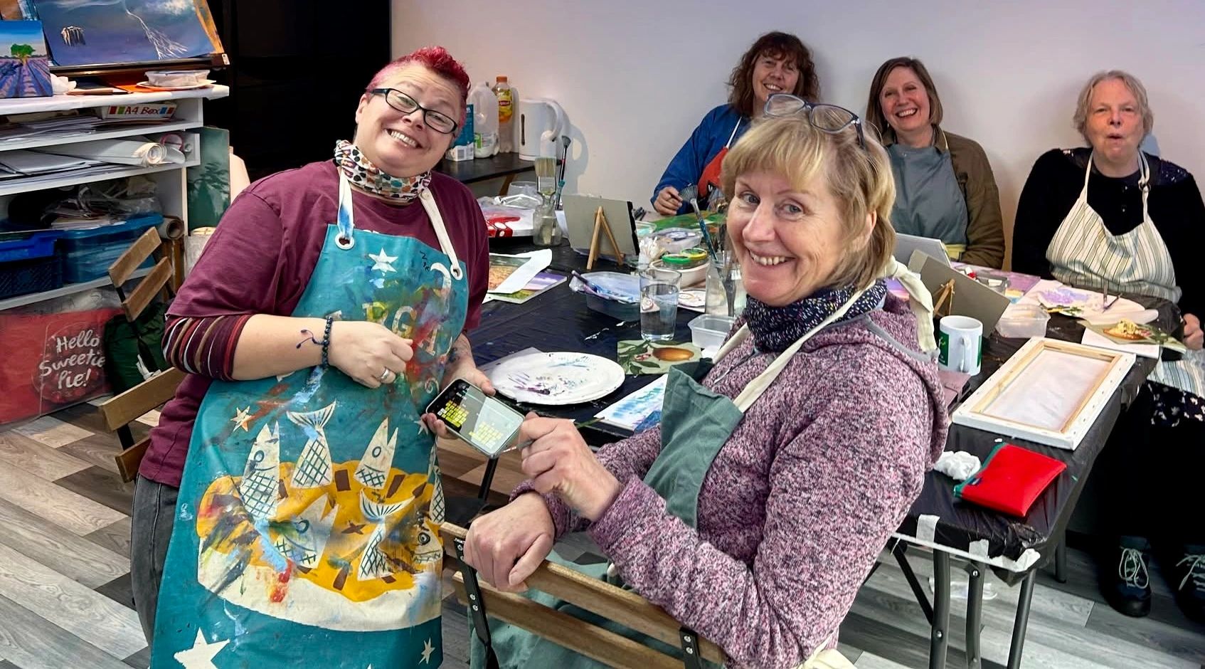Group of women smiling in a painting class.
