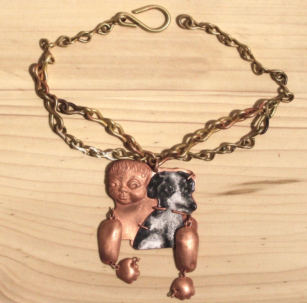 A unique necklace with a baby and dog pendant.