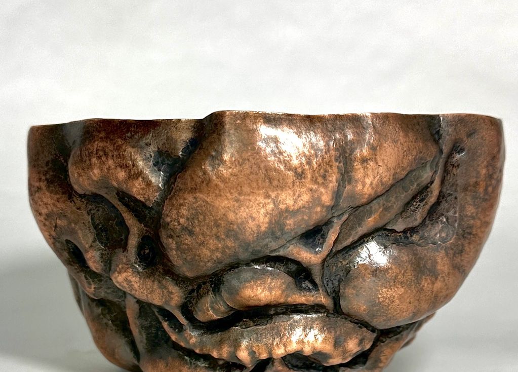 Close-up of a textured bronze or copper bowl.