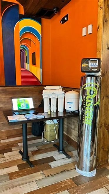 Water filtration system setup against an orange wall with colorful arch artwork.
