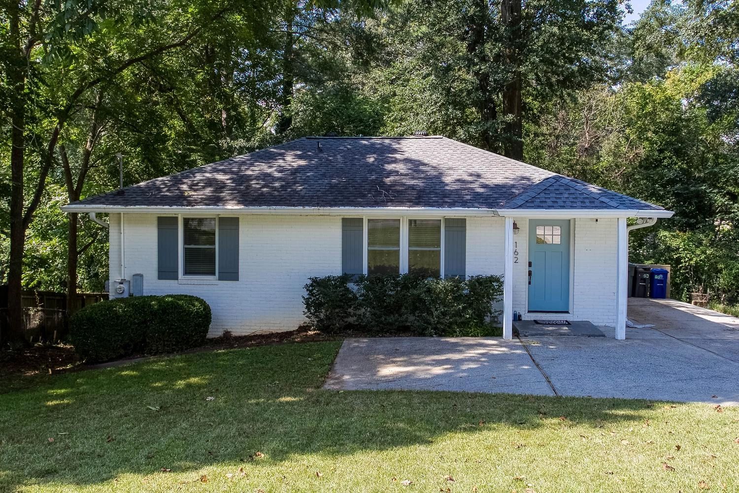 Small white house with blue door and gray shutters.