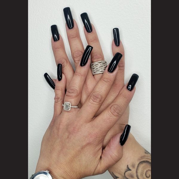 extra long black nails done by a nail technician