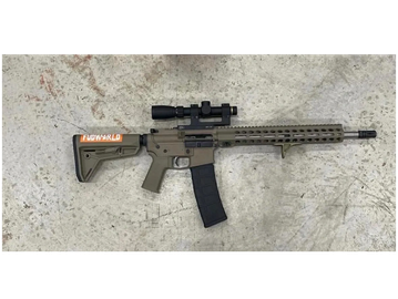 A modern rifle with a scope on a concrete surface.