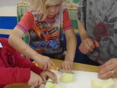 A child safely cuts an apple with a knife 