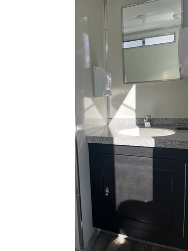 Vanity with porcelain sink. Soap dispenser and mirrror