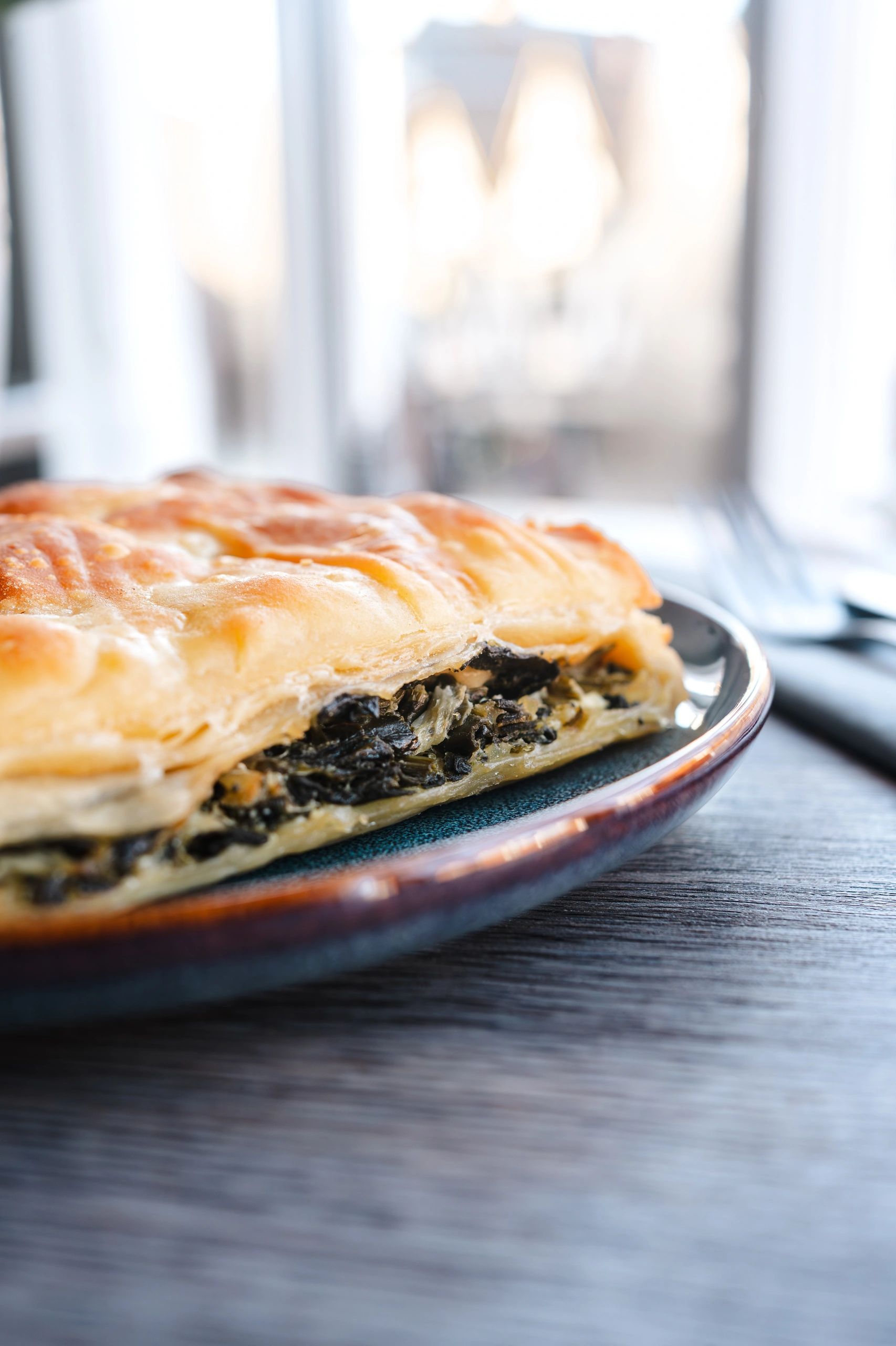 Close-up of a spinach pie slice on a plate.