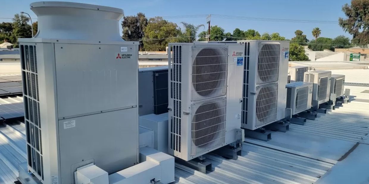 Row of outdoor Mitsubishi Electric air conditioning units on a rooftop.