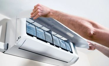 Person opening an indoor air conditioner unit.