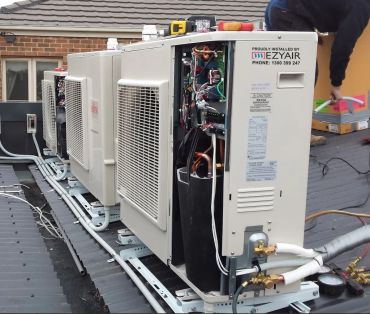 Air conditioning units being installed on a rooftop.