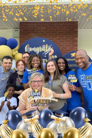 Group celebrating Jade's graduation in 2026 with balloons and signs.