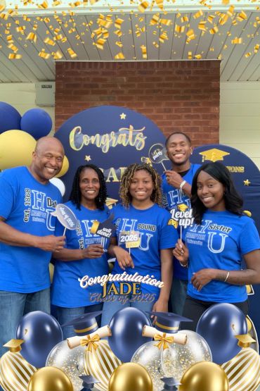 Family celebrates Jade's graduation with smiles and congratulatory signs.