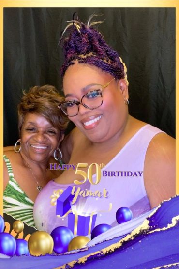 Two women smiling at a 50th birthday celebration.