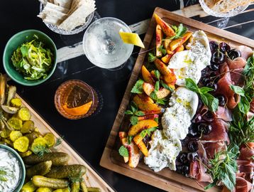 Charcuterie board with drinks and side dishes.