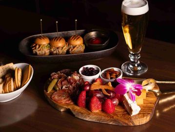 Charcuterie board with sliders and beer.