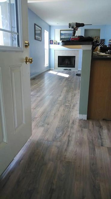 Newly installed wood flooring in a bright living room with a fireplace.