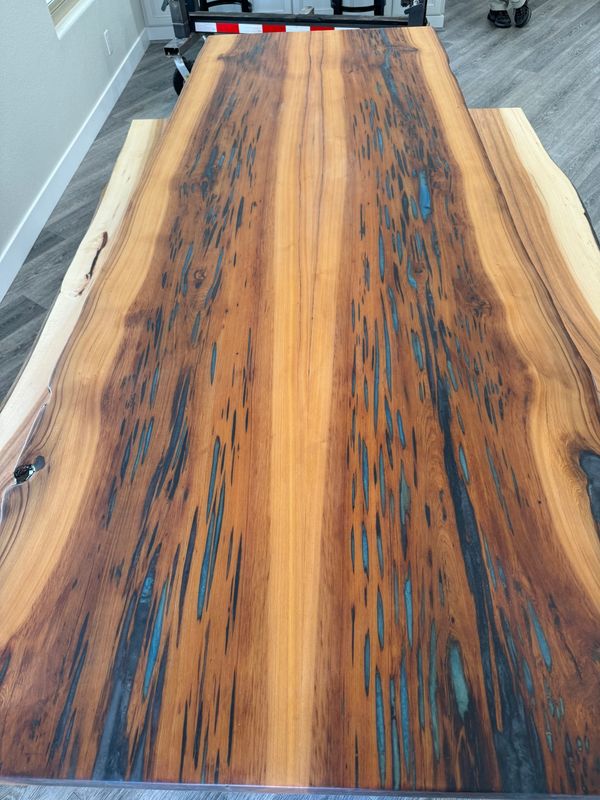 Live edge bookmatched sinker cypress dining table with Caribbean epoxy accents