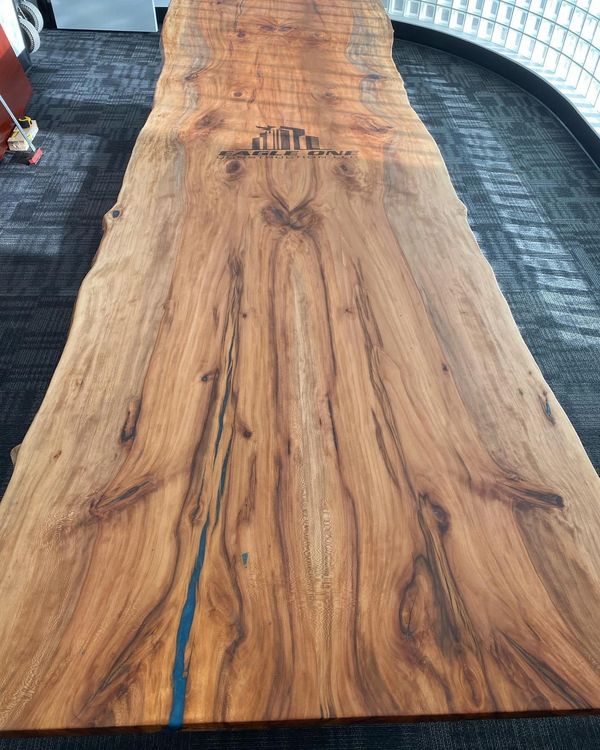 custom 57x168’ Spalted Sycamore conference table engraved with their company logo and Weighing about
