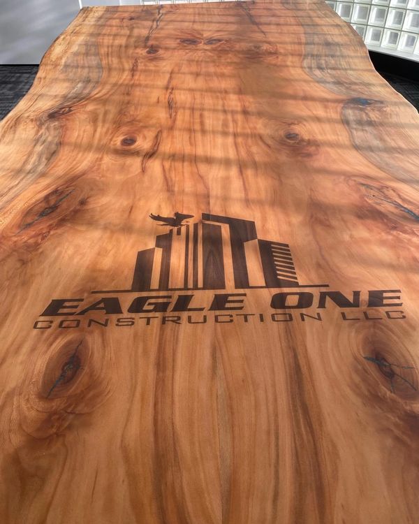 custom 57x168’ Spalted Sycamore conference table engraved with their company logo and Weighing about
