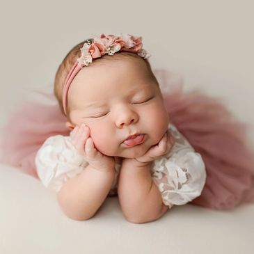 Froggy pose of a baby girl with a tutu on