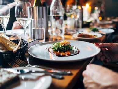 Elegant dining setting with gourmet plated dish and wine glasses.