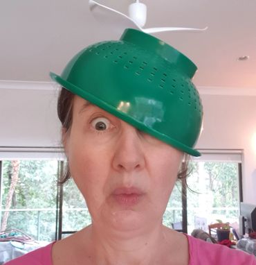 Meli Bee author, writer of children's books, wearing a collander on her head! Melissa Rae Brett 2021