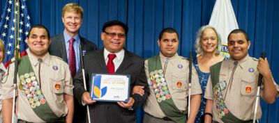 Ollie and his sons Leo, Steven, and Nick in boy scout uniforms holding white canes, with two others.