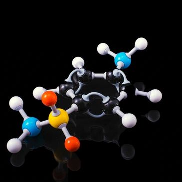 Colorful molecular model on a reflective black surface.