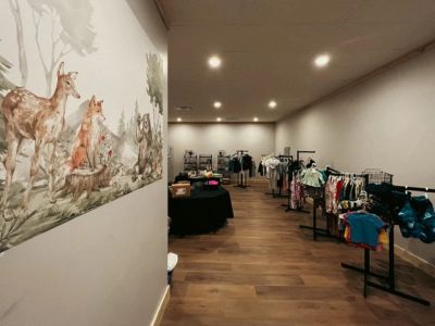 Boutique with animal mural and clothing racks.