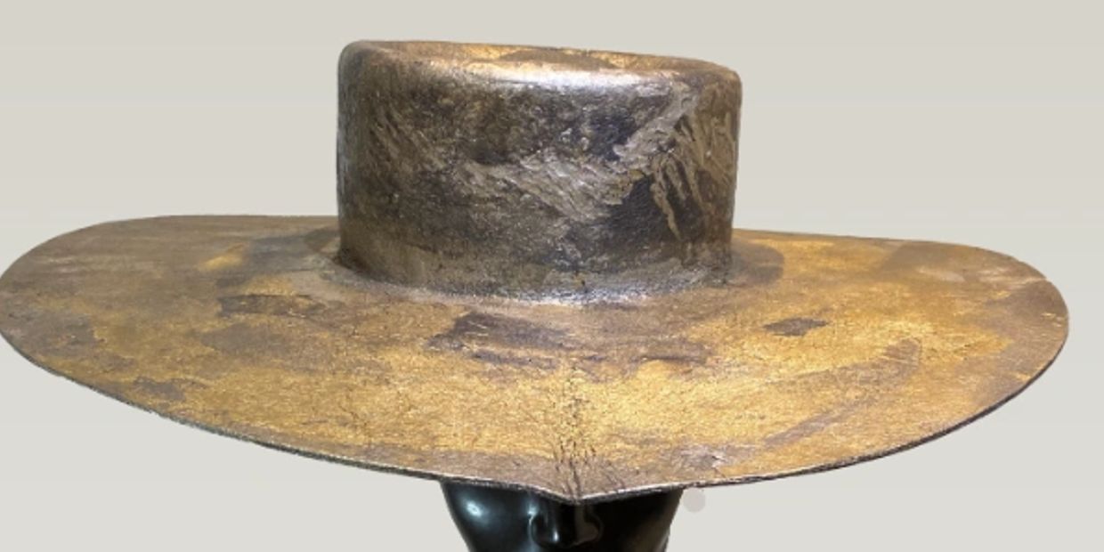 Wide-brimmed, weathered hat with a tall crown.