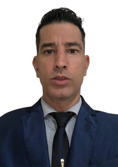 Man in a blue suit and black tie looking at the camera.