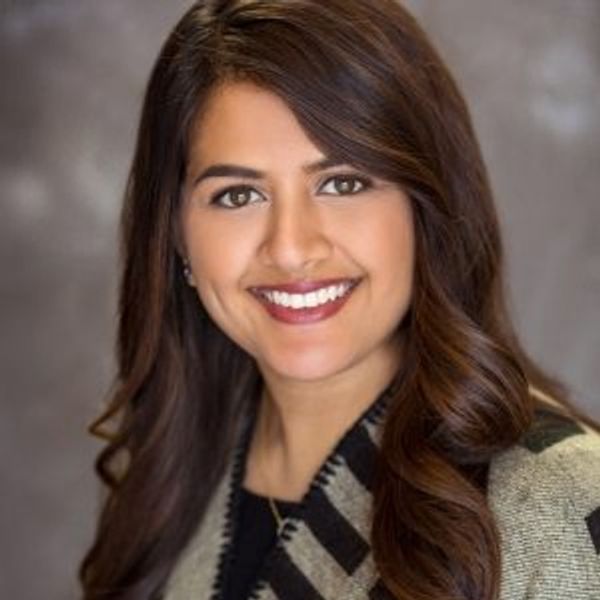 Professional portrait of a smiling woman with long brown hair.