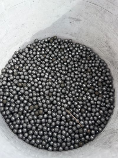 A bucket filled with many small metal balls.