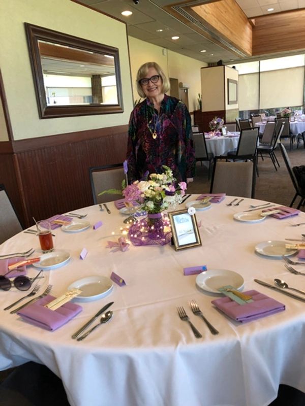 Table setting  with lavender napkins matching the centerpieces.