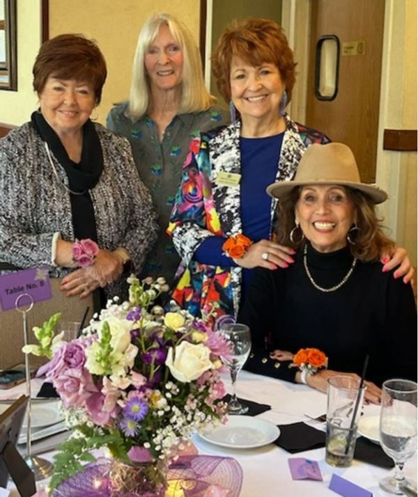 Four Westlake Village Garden Club members at their table with a flower centerpiece.