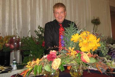 garden club member in front of a selection of fresh flowers