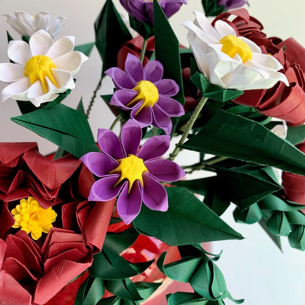 bouquet of origami daisies in white and purple with red peonies