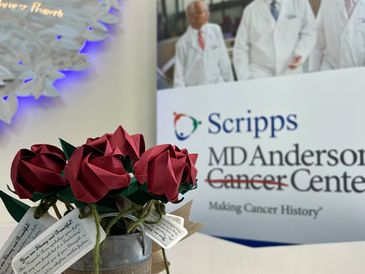 handmade origami roses in a vase with a support message to cancer patients, over a hospital counter 