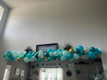 Blue and gold balloon garland decorating an indoor archway.